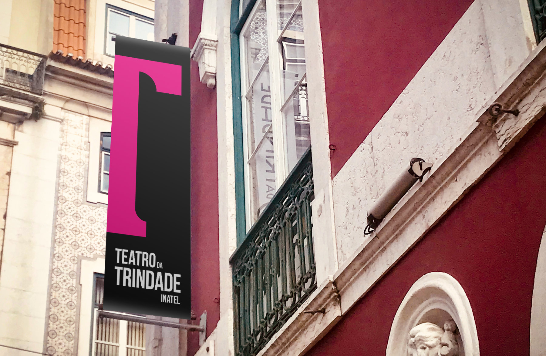 Simulação de pendão preto com símbolo magenta na fachada do Teatro da Trindade.